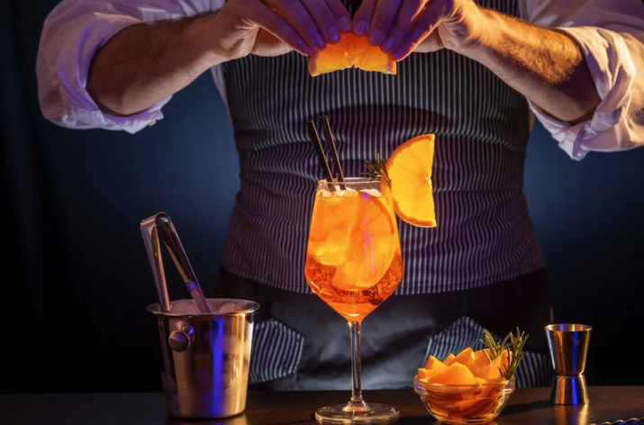 Bartender making a cocktail with orange slices